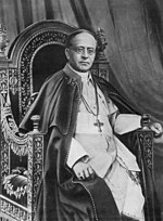 Pope Pius XI in ordinary dress: zucchetto, pectoral cross, cassock, and the papal tabarro, that similar to the ferraiolo.