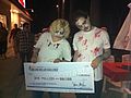 Two zombies hold a check for one million dollars for James Van Praagh if he can prove he can talk to the dead.