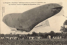 A damaged semi-rigid airship sags under the weight of its gondola.