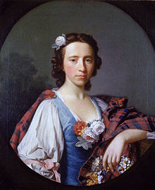 Portrait of young woman in a blue and white dress with predominantly red tartan plaid around her shoulders, and several white roses, a Jacobite symbol.