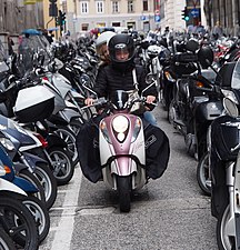 Rider looking for a place at parking lot in Trieste, where use of a scooter in city transport is among highest in Italy.[citation needed]