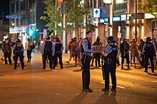 Minneapolis police in riot gear mingle with demonstrators on West Lake Street in the Uptown neighborhood just after midnight on June 4, 2021