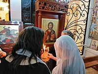 Christian and Druze women light candles in St. George's Cathedral, As-Suwayda