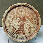 Fig. 3. Winged Gorgon with, volute nose, wide mouth, tusks/fangs, tongue, and beard, as Mistress of Animals flanked by geese; plate from Kameiros, Rhodes, British Museum A 748 (late seventh century BC)[63]