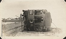 An interurban railcar lays on its side off of its tracks