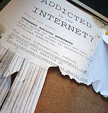 A flyer on a corkboard reads, "ADDICTED to the INTERNET?" and gives information for meeting up with an "Internet addicts anonymous" group. Some tabs at the bottom with contact information have already been pulled off.