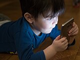 A young boy engaged with a smartphone