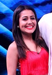 Neha Kakkar smiling wearing a red top