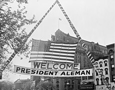 Photograph of U.S. flag and welcoming banner hung over a Washington street during ceremonies in honor of visiting President Miguel Alemán Valdés.