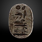 Small greyish oval seal with hieroglyphs on it.