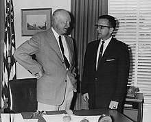 Dwight D. Eisenhower, left, in a bright-colored suit, talks to Ted Stevens, right, in a dark colored suit, circa 1958