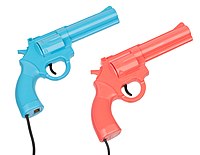 Three colored plastic lightgun game controllers resembling real-world guns, laid out on a floorspace