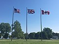 Flags of Canada, the U.S., and the U.K. fly next to the memorial at equal height.