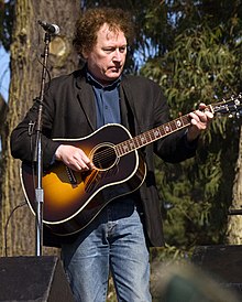 A photograph of Randy Scruggs playing a guitar.