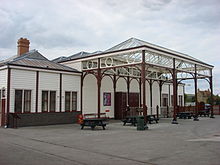 Large white wooden building with a large glass canopy