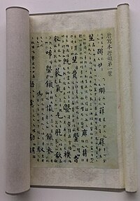 A scroll with Chinese writing, with large head characters