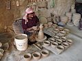 Image 45An artisan making pottery using the traditional mud and water mixture on a revolving wheel. (from Bahrain)