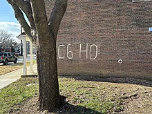 "C6 H0" painted in white on the side of a brick building