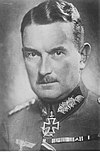 A man with mustache wearing a military uniform with an Iron Cross displayed at the front of his uniform collar.