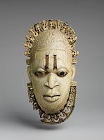 Benin ivory mask of the queen mother Idia; 16th century; ivory, iron & copper; Metropolitan Museum of Art. One of four related ivory pendant masks among the prized regalia of the Oba of Benin taken by the British during the Benin Expedition of 1897