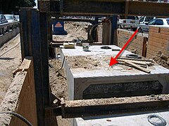 Red arrow marks a prefabricated element of a utility tunnel already placed in the trench