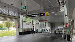 Photograph of the station entrance with the sign indicating the station name and alphanumeric code (CC5). The entrance is connected to a sheltered linkway.