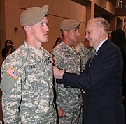 Retired Colonel Ralph Puckett places the Ranger Scroll on two graduates of the Ranger Assessment and Selection Program, 5 January 2010