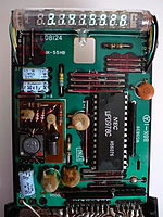 The interior of a Casio fx-20 scientific calculator from the mid-1970s, using a VFD. The processor integrated circuit (IC) is made by NEC (marked μPD978C). Discrete electronic components like capacitors and resistors and the IC are mounted on a printed circuit board (PCB). This calculator uses a battery pack as a power source.