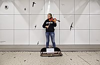 Violinist in the hallway connecting the station's train and metro portions