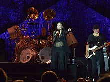 Turunen is seen singing, accompanied by a guitarist and drummer.