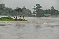 People on an island in a flooded river in Bangladesh
