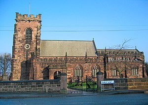 A stone Gothic church with battlemented parapets and tower
