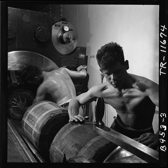 Barbette of 16" gun on board the USS New Jersey (BB-62). Gunners packing in bags of powder which will fire the huge shell already in gun. [Nov 1944][13]