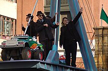 Good Charlotte standing on a parade float while waving