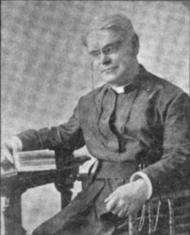 Photograph of Doonan seated with one arm atop a stack of books