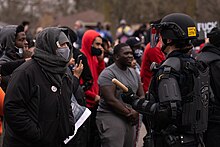 Protesters near the location where Wright was killed, facing a police officer in riot gear