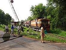 Train at grade crossing, with bicyclists waiting to cross