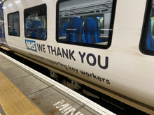 Near view of a Class 331 unit with "NHS WE THANK YOU" on its side