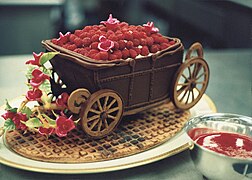 Chocolate carriage with raspberries on waffle cookie