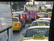 Photograph of two lanes of cars, buses and taxis at a standstill in a traffic jame