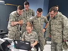 General Armacost and several cadets looking at a computer