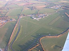 aerial view of two runway grass airfield and perimeter road