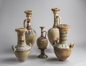 Whitewashed amphorae with colourful floral designs on the shoulders