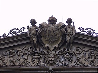 Pura Mangkunagaran coat of arms flanked by European style cherubs and a Dhwarapala