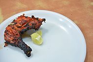 A portion of a tandoori chicken, at a restaurant in India.