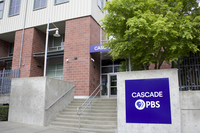 The building of Cascade PBS, showing the organization's PBS logo and the staircase leading up to the visitor entrance.