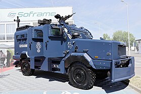 Front quarter view of the Multipurpose gendarmerie intervention vehicle with open doors and machine gun on the roof