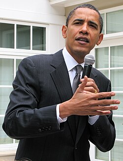 Picture of a man holding a microphone and talking and gesturing