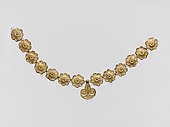Mycenaean necklace; 1400–1050 BC; gilded terracotta; diameter of the rosettes: 2.7 centimetres (1.1 in), with variations of circa 0.1 centimetres (0.039 in), length of the pendant 3.7 centimetres (1.5 in); Metropolitan Museum of Art (New York City)