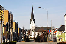 Foto einer Kirche aus einiger Entfernung am Ende einer mit Wohnhäusern gesäumten Straßen